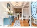 Inviting foyer with hardwood floors, a coffered ceiling, blue cabinet, staircase, and an open view to the living spaces at 104 Crosby Ln, Sanford, NC 27330