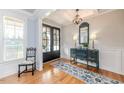 Bright foyer featuring hardwood floors, a decorative chandelier, and a stylish console table with blue accents at 104 Crosby Ln, Sanford, NC 27330