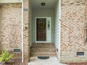 Inviting front entry with brick accents, steps leading to door, and a decorative wreath at 107 Covington Dr, Chapel Hill, NC 27514