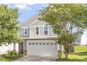 View of a charming two-story home with a two-car garage and well-maintained lawn at 110 Bray Dr, Mebane, NC 27302