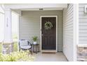 Inviting front porch features a seating area and a welcoming wreath on the dark front door at 110 Bray Dr, Mebane, NC 27302