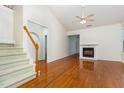 Bright living room with hardwood floors, fireplace, vaulted ceiling, and staircase to the second level at 11005 Louson Pl, Raleigh, NC 27614