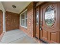 Inviting front porch with decorative glass front door and brick columns at 1124 Kalworth Rd, Wake Forest, NC 27587