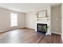Cozy living room boasts a fireplace and hardwood floors; filled with natural light from a large window at 118 Rhum Pl, Garner, NC 27529
