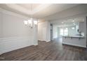 Elegant dining room with wainscoting, chandelier, and open view to the kitchen, perfect for entertaining at 120 Newport Lndg # 99, Garner, NC 27529