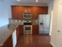 Well-equipped kitchen with stainless steel appliances, wood cabinets, and granite countertops at 1304 Cozart St # 119, Durham, NC 27704