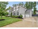 Two-story gray home showcasing a three car garage and long driveway at 1324 Sandybrook Ln, Wake Forest, NC 27587