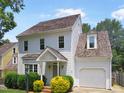 Charming two-story home with shake siding, a front porch, and mature landscaping under a blue sky at 137 Wintermist Dr, Cary, NC 27513