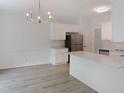 Modern kitchen featuring an eat-in bar, stainless steel appliances, and white cabinets for ample storage at 137 Wintermist Dr, Cary, NC 27513