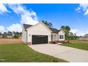 View of the front of a single-story home with a driveway and lawn at 162 Gumtop Dr, Zebulon, NC 27597