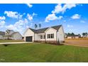 Exterior view of a single-story home, showcasing its well-kept lawn and neighborhood setting at 162 Gumtop Dr, Zebulon, NC 27597
