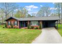 Lovely home with a brick facade, complemented by green landscaping and a convenient attached carport at 1813 Grady Dr., Durham, NC 27712