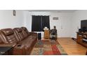 Comfortable living room features a leather sofa, modern furniture, and a neutral color palette at 1824 Vintage Rd, Raleigh, NC 27610