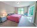Bright, carpeted bedroom with a sliding glass door and large window at 186 St. Andrews Ln, Chapel Hill, NC 27517