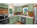 Cozy kitchen with painted cabinetry, stainless steel appliances, and vintage-style backsplash at 1869 Brevard Rd, Graham, NC 27253