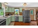 Inviting kitchen with painted cabinets, stainless steel appliances, and view to backyard at 1869 Brevard Rd, Graham, NC 27253