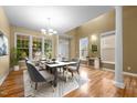 Bright dining room featuring hardwood floors, modern chandelier, large windows, and elegant decor at 2067 Glenkirk Dr, Burlington, NC 27215