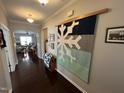 Inviting hallway featuring hardwood floors and a stylish snowflake-themed wall hanging at 2535 Kinglass Dr, Fuquay Varina, NC 27526