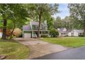 Charming green house with a detached garage and a long driveway winding through the front yard at 2724 Glastonbury Rd, Apex, NC 27539