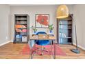 Bright office featuring wood floors, bookshelves, a stylish desk, and a comfortable blue chair at 3027 Courtney Creek Blvd, Durham, NC 27713