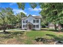 Exterior view of a charming two-story home, showcasing board and batten siding and a well-kept front yard at 305 W Canary St, Dunn, NC 28334