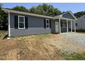 Charming home featuring gray siding, black shutters, and a welcoming front porch at 311 W Market St, Graham, NC 27253