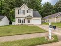 Charming two-story home featuring a manicured lawn, attached garage, and inviting curb appeal with a mailbox displaying '4020' at 4020 Mindspring Dr, Raleigh, NC 27610