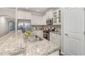 Bright kitchen featuring granite countertops, stainless steel appliances, and white cabinetry at 43 Salt Cedar Ln, Chapel Hill, NC 27516