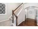 Carpeted staircase with a wood railing and white spindles, adjacent to a hallway with gleaming hardwood floors at 43 Salt Cedar Ln, Chapel Hill, NC 27516