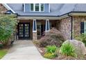 Inviting front entrance with a stylish glass front door, stone accents, and lush landscaping at 4924 Stoneyoak Ln, Raleigh, NC 27610