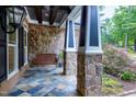 Cozy front porch with stone pillars, swing, and beautiful tile flooring at 4924 Stoneyoak Ln, Raleigh, NC 27610