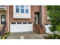 Brick townhome featuring attached garage, brick entry stairs, and neutral trim at 5321 Cambridgeshire Loop, Cary, NC 27519