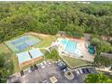 Aerial view of community amenities featuring tennis courts, a swimming pool, and ample parking at 5512 Grand Traverse Dr, Raleigh, NC 27604
