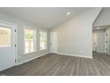 Bright living room featuring sleek gray flooring, recessed lights, neutral paint, and plenty of natural light at 5576 Foothills Ct, Snow Camp, NC 27349