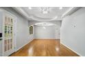 Bright, spacious living room with hardwood floors and decorative tray ceiling with a modern chandelier at 5820 Wake Forest Hwy, Durham, NC 27703