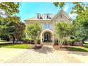 Inviting brick home with arched doorway, manicured lawn, and lush landscaping at 6005 Carlyle Dr, Raleigh, NC 27614