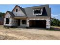 New construction featuring a brick base and a modern, open garage at 6332 River Rd, Fuquay Varina, NC 27526