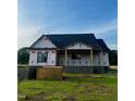 New construction home with a black roof, wrapped in white material, set on a green grassy lot at 6332 River Rd, Fuquay Varina, NC 27526
