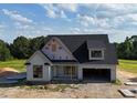 Modern design on a two-story home featuring an attached two car garage, black roof and contrasting white siding at 6332 River Rd, Fuquay Varina, NC 27526