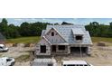 Aerial view of the new construction home, surrounded by trees and construction materials under a bright blue sky at 6332 River Rd, Fuquay Varina, NC 27526
