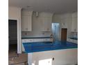 Bright kitchen featuring white cabinets, brass hardware, and a blue covered kitchen island and countertops at 701 Locust Ln, Raleigh, NC 27603