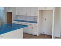 A bright kitchen is showcased by the white cabinetry and stainless steel appliances at 701 Locust Ln, Raleigh, NC 27603
