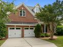 Lovely brick home with a two-car garage, manicured landscaping, and a brick pathway to the entrance at 7409 Chesley Ln, Durham, NC 27713