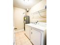 A functional laundry room with a washer, dryer, and storage shelves, perfect for convenience at 115 Ballyliffen Ln, Cary, NC 27519