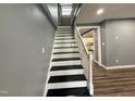 Modern staircase features dark wood treads, white risers, and a matching handrail at 119 N Anthony St, Burlington, NC 27217