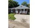 Charming brick home with a covered front porch, well-maintained lawn, and concrete driveway at 1210 Fayetteville St, Smithfield, NC 27577