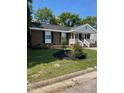 Charming brick home with a covered front porch, well-maintained landscaping, and black shutters at 1210 Fayetteville St, Smithfield, NC 27577