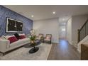 Stylish living room with blue accent wall, modern furnishings, and hardwood flooring at 1227 Bessie Ct, Wake Forest, NC 27587