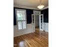Stylish living room featuring black accent walls, classic trim, hardwood floors and double glass doors at 126 Riverglade Dr, Clayton, NC 27527