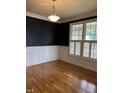 Cozy living room with dark accent walls, white trim, hardwood floors and plantation shutters at 126 Riverglade Dr, Clayton, NC 27527